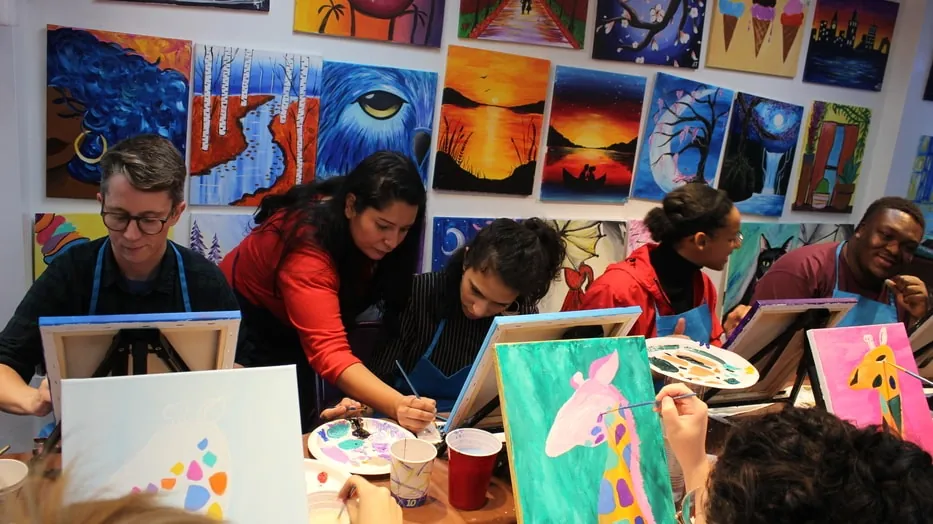 An instructor helping guests paint in the studio