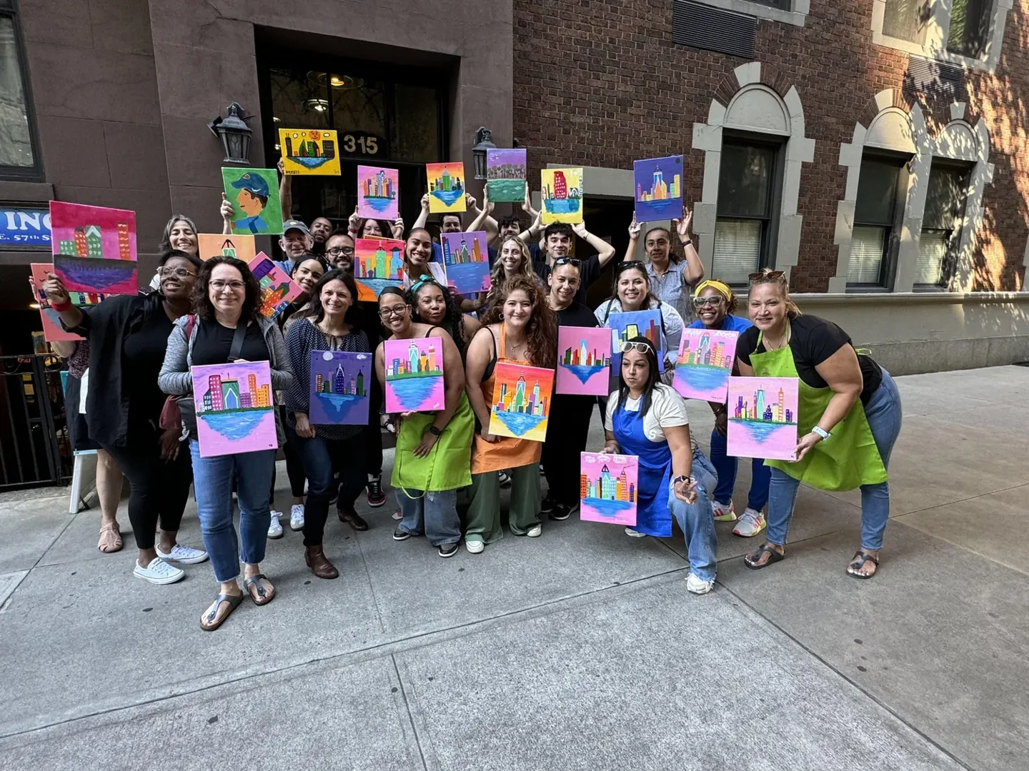 A group celebrating together with colorful skyline paintings