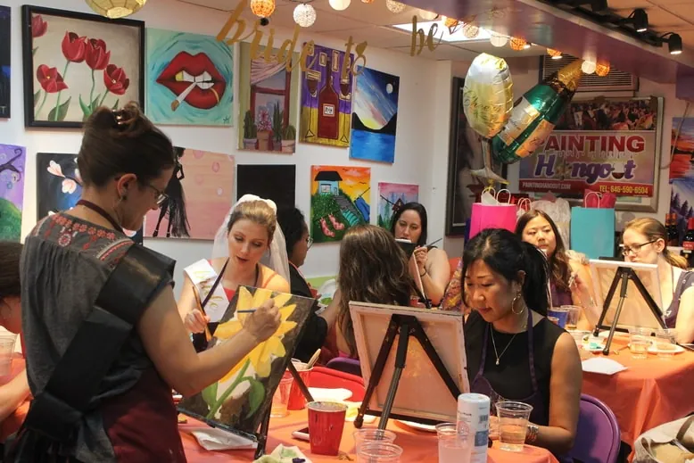 An instructor guiding guests through their paintings