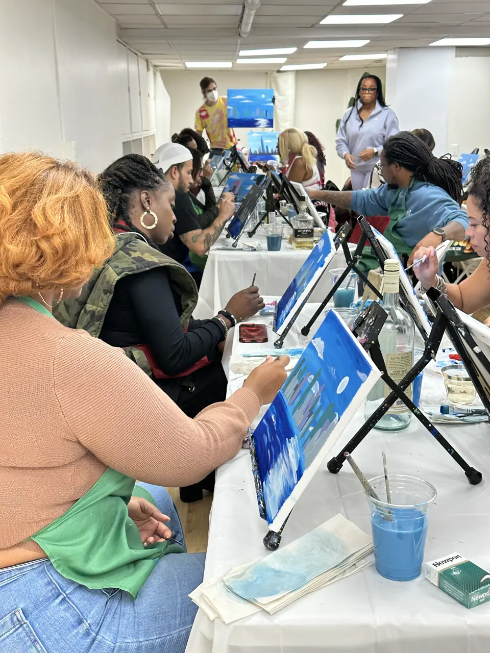 Guests painting blue cityscapes around the studio table