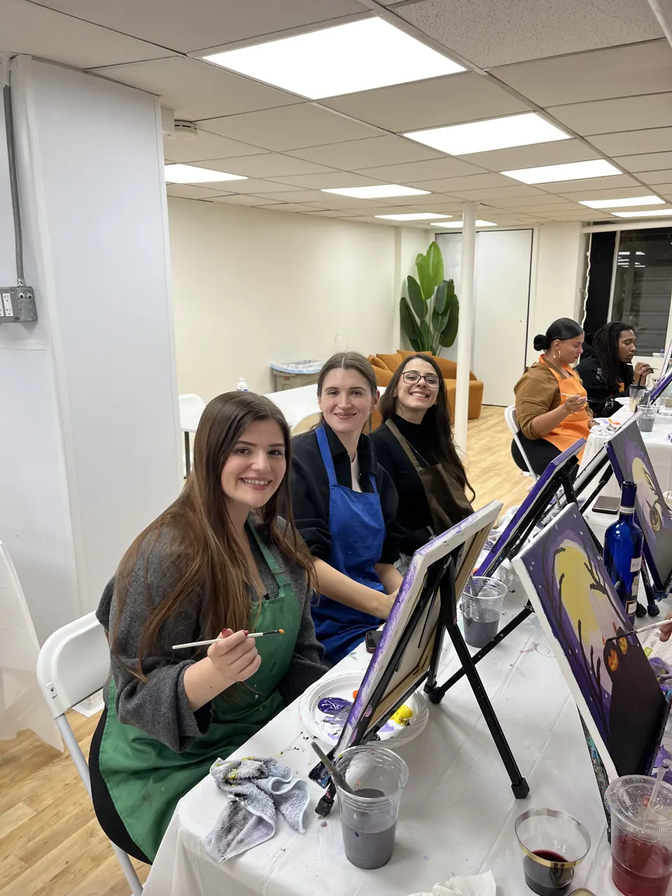 Smiling guests enjoying a painting session together